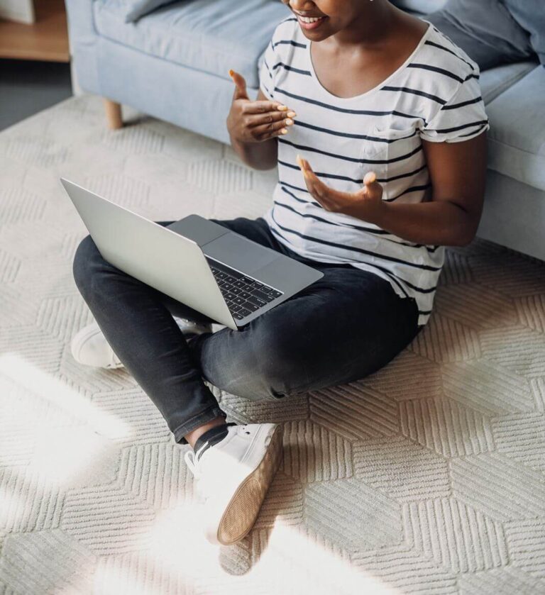 An individual sitting down criss cross on the ground talking to their laptop. Our continuing education online for therapists is made convenient for you. Read our blog for more insights!