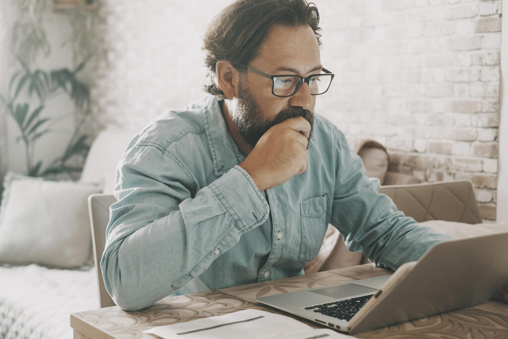 therapist thinking | therapist ceu | ceus for therapists | ceus for counselors | Texas | Michigan | Utah A male therapist resting his hand on his chin thinking & looking at his laptop. Continuing education for counselors can be done online & in an engaging way! Don't let CEs bore you.