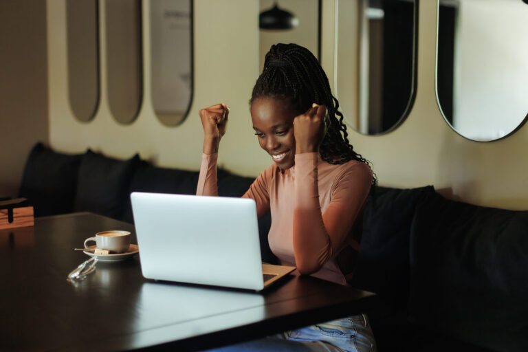 A therapist clenching their fists in success while smiling at their computer. This represents the feeling of success after completing your online continue education for therapists! Discover how we can help you today by reading our blog.