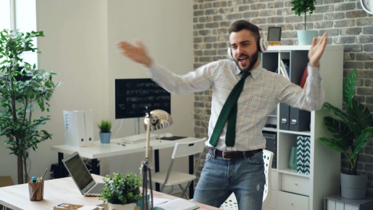 A man standing up at his desk while dancing around in a good mood. Representing how our continuing education for therapists & counselors keep you entertained & interacted! Get started with our online CE courses today!
